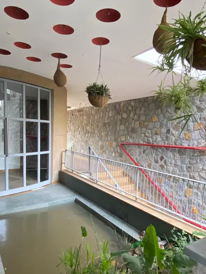 The combination of the pond, hanging plants, and earthen pot nests creates a multi-layered habitat for various species to coexist with the human inhabitants.