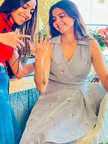A friend admiring the beautiful mehndi design, complete with the groom's initial. These small, personal touches make the day even more special.