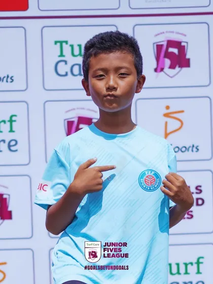 Pointing to the crest, this player shows pride in his team. I help build team spirit and a sense of belonging among young athletes.