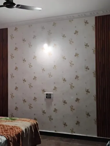 A bedroom wall with a combination of floral wallpaper and wood-paneled sections. This mix of materials adds texture and visual interest.