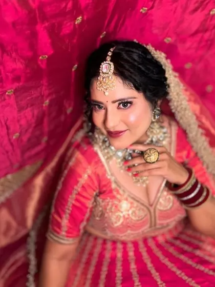 A bride looking radiant in a pinkish-red lehenga. This image shows the beautiful flare of the skirt, perfect for bridal portraits.