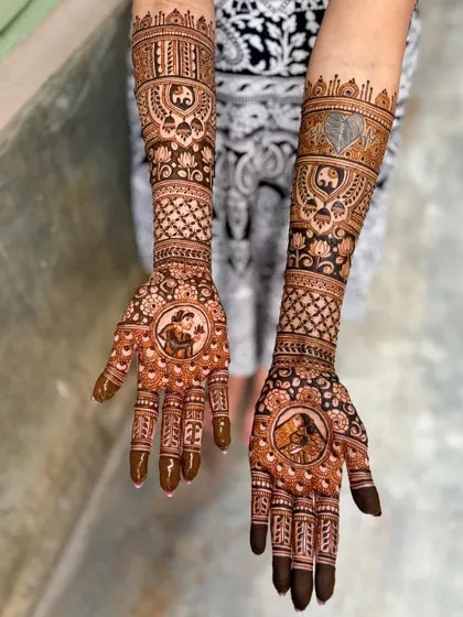 An angled view of the portrait mehendi, showing the contrast between the detailed portraits and the intricate patterns on the arms.