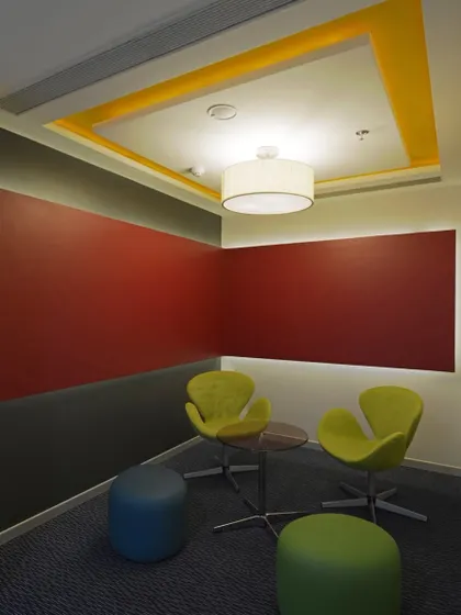 Bright primary colors add energy to this small meeting room. The space is designed for quick, informal chats and brainstorming sessions.