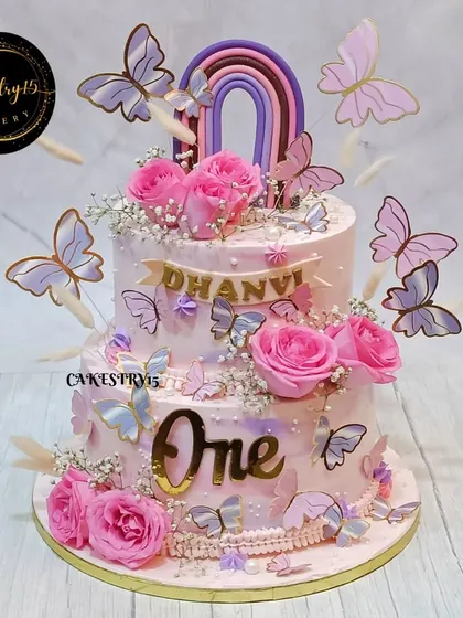 We created this stunning 5kg choco-vanilla cake for a first birthday, featuring real roses, delicate butterflies, and a fondant rainbow. The soft pink and lavender tones make it a truly dreamy centerpiece.