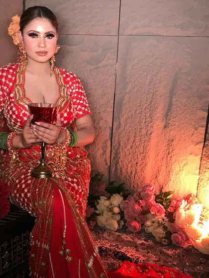 A contemporary look with a vintage feel. The model holds a wine glass, adding to the sophisticated and moody vibe of this red and orange ensemble.
