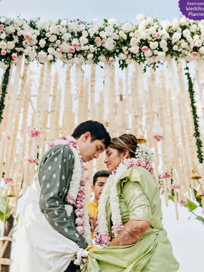 A beautiful, intimate moment between the couple during their wedding ceremony. The mandap featured a stunning ceiling of cascading floral hangings.