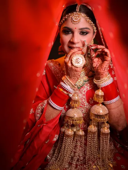 A direct and confident gaze from our bride, showcasing her complete look. The makeup is designed to be bold yet elegant, perfectly framing her face and complementing her intricate bridal jewelry.