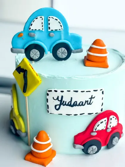 Beep beep! A car-themed cake for a little one who loves things that go. This features handmade, cartoonish fondant cars, traffic cones, and road signs.