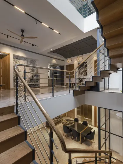 This view from the staircase of the Screen House shows the double-height volume connecting the ground floor to the upper lounge. The open design allows light and interactions to flow freely between floors.