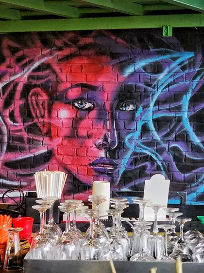 A close-up of the abstract face mural, created with red and blue spray paint to give it a fiery and cool dual-toned effect.