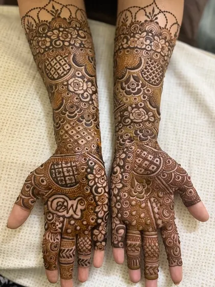 A beautiful three-quarter length Indian design that also includes the couple's initials, "N" and "W," on the palm. It is a popular way to personalize the bridal mehendi.