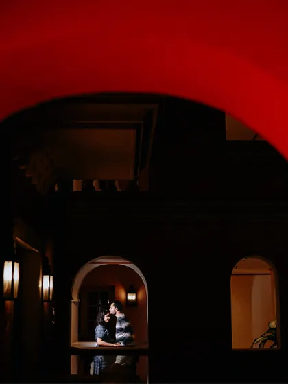A creative and artistic shot, framing the couple through a bold red archway. This adds a unique compositional element to their Goa pre-wedding story.