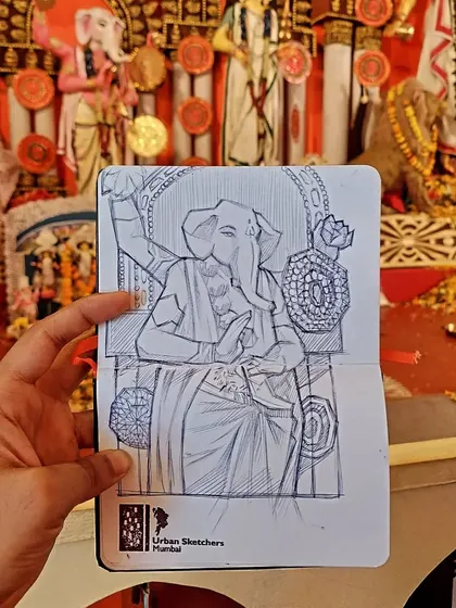 Live sketching at festivals allows me to capture the spirit of the celebration as it happens. Here is a ballpoint pen drawing of a Ganesha idol, sketched on-site at a local Durga Pooja pandal. The background shows the actual pandal, giving a sense of the lively environment I work in.