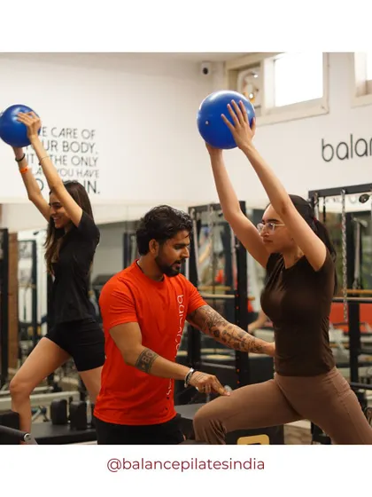 Our trainer guiding a client through a lunge with the stability ball, ensuring her form is perfect.