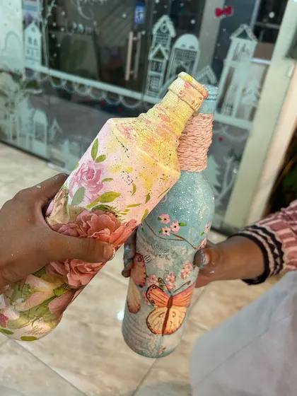 Two beautifully finished decoupage bottles. This craft involves decorating surfaces with paper cutouts for a gorgeous, vintage look.