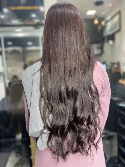 Long, dark hair styled with soft, elegant waves at the ends for a classic and polished look.