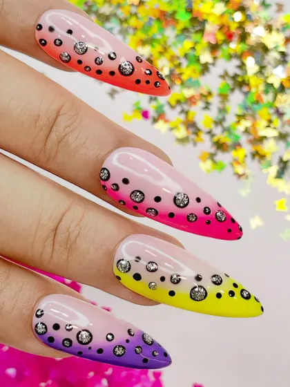 Colorful ombre nails with black dots and rhinestone details, another creative and stylish option for Holi.
