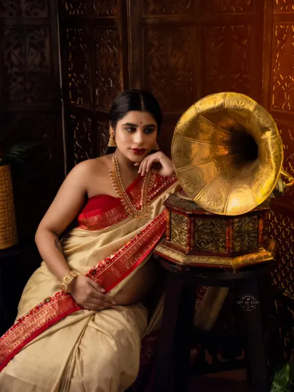 We blend tradition with art in this conceptual maternity saree shoot. This portrait, inspired by classic Indian aesthetics with a vintage gramophone, captures a timeless elegance and quiet contemplation.