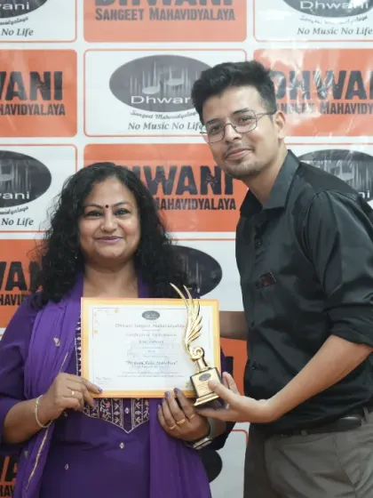 A teacher presents an award to his adult student.