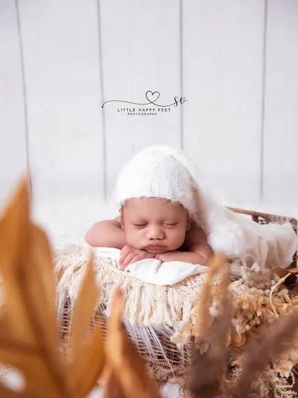 A beautiful boho-chic portrait. The neutral colors, dried foliage, and simple white hat create a look that is both rustic and elegant.