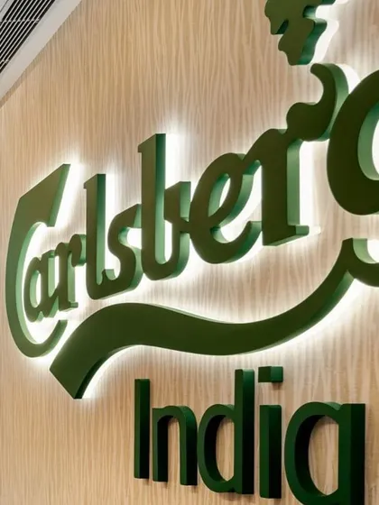 The backlit Carlsberg India logo, a key branding element that makes a bold statement in the office.