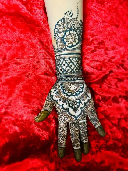 A single hand adorned with a heavy, intricate design. The combination of a mandala, jaal pattern, and bold cuff creates a very rich and traditional look.
