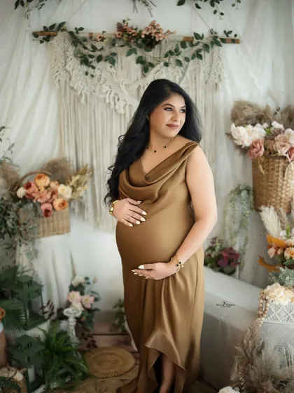 A confident and radiant portrait of a mother-to-be. The side lighting highlights her beautiful features and the elegant drape of her satin gown.