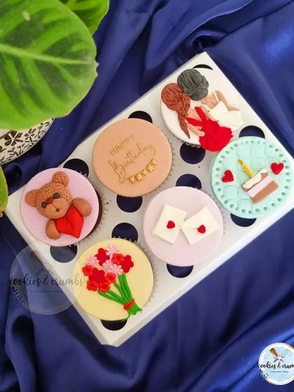 A beautiful set of custom cupcakes for a best friend's birthday. Each topper tells a little story, with designs like a teddy bear, a bouquet of flowers, and two best friends.
