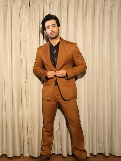 This full-length view of Satyajeet Dubey's brown suit highlights the perfect fit and flare of the trousers, designed to complement the structured jacket. It's a complete look rooted in traditional craftsmanship.