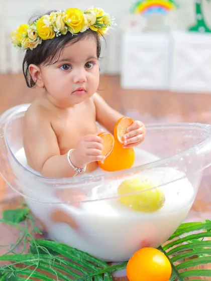 A quiet, curious moment during the milk bath session. This little one is carefully examining her orange slice, creating a sweet and natural portrait.