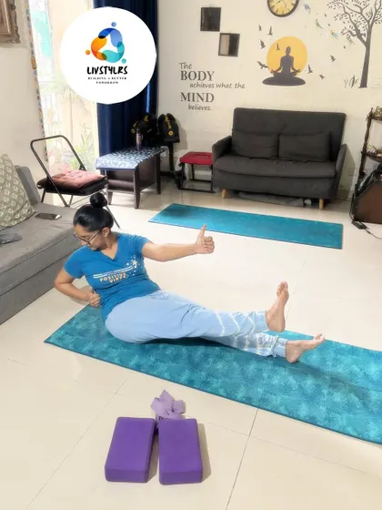 A client gives a thumbs-up while holding a challenging core pose, showing her strength and positive attitude during the session.