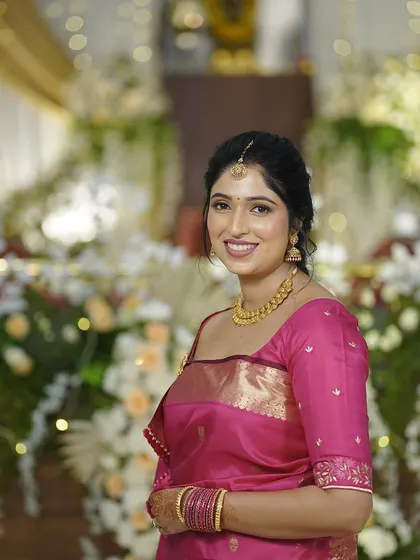 This portrait captures the bride's radiant smile and the beautiful details of her makeup and gold jewellery.
