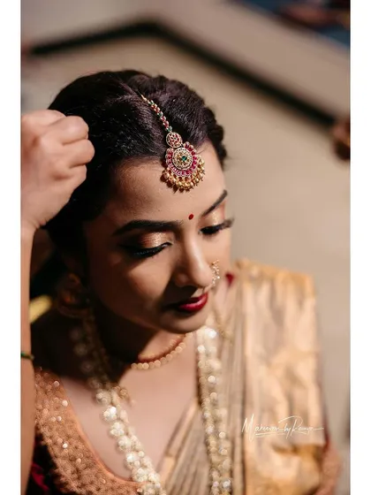 A close-up of Ashwini's bridal makeup, showing the intricate details of her eye makeup and perfectly placed bindi.