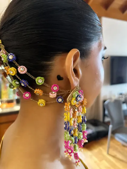 A close-up of the stunning earrings that are connected to the hair accessory. This is a perfect example of how to coordinate your jewelry and hair for a complete look.
