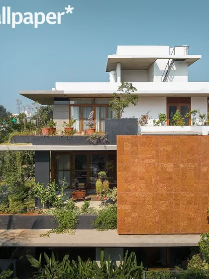 Another perspective from the Wallpaper* feature, showing the laterite stone facade and the layered green terraces.