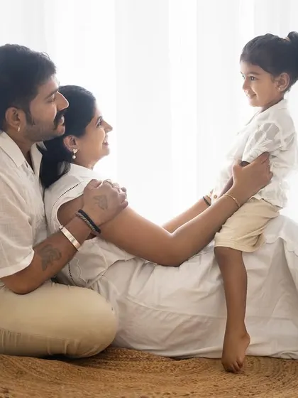 A lovely, interactive family moment on the floor. The focus is on the connection between the parents and their child.