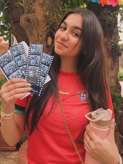 A proud student showing off her collection of photo strips from Cul Week at MCC.