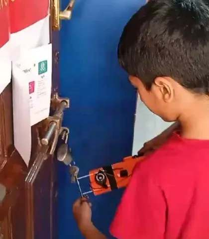 Putting the project to the test. A student uses the metal detector he built to see if it can detect the metal lock on a door. This is the final, rewarding step of the engineering process.
