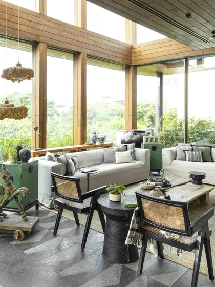 The conservatory features granite flooring with a unique pattern, chairs by Mahendra Doshi, and light installations by Oorjaa. The entire space is a curated collection of handcrafted pieces that exude a peaceful, timeless charm.