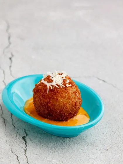 A bite of pure luxury. Our Potato Rellons Truffleadas are crispy, golden-fried potato balls infused with the rich, earthy flavour of truffle, served on a bed of creamy sauce.