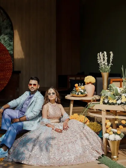 A stylish groom and bride at their Haldi ceremony, with the groom wearing custom Nike Air Force 1s designed to match his unique wedding attire.