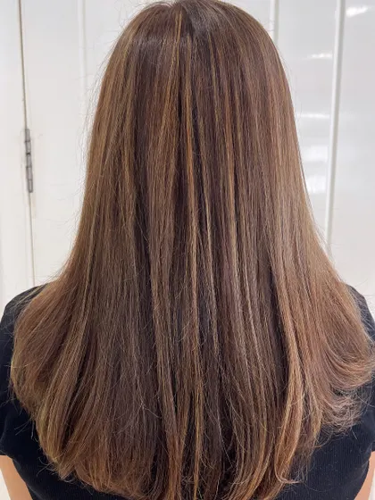 A beautiful example of our subtle highlighting technique. These fine, natural-looking highlights blend seamlessly into the base color for a sun-kissed effect on straight, healthy hair.