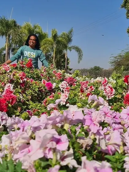 Standing in a field of pink and white flowers with palm trees in the background. It is a blessing to do what I love every single day.