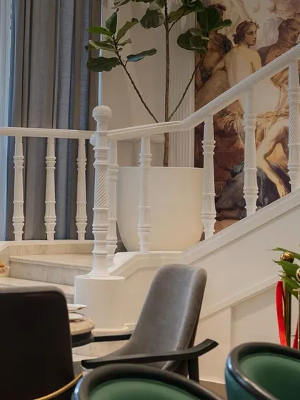 The grand staircase at Begeterre, flanked by our custom seating arrangements. We design furniture layouts that enhance the natural flow and grandeur of a commercial space.