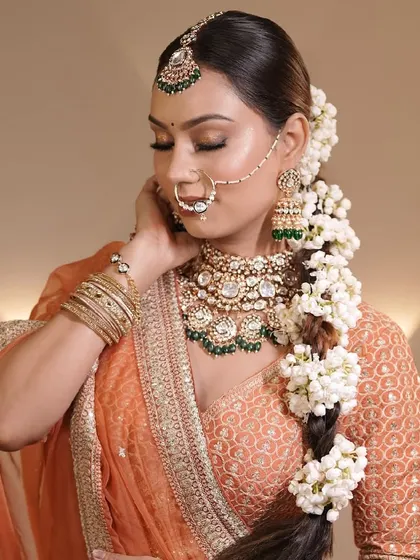 The complete bridal look, featuring a floral braid adorned with fresh mogra flowers. This hairstyle is a timeless choice for brides who want a traditional yet elegant look.