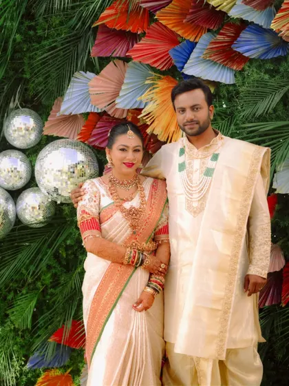 The happy couple posing against the festive backdrop.