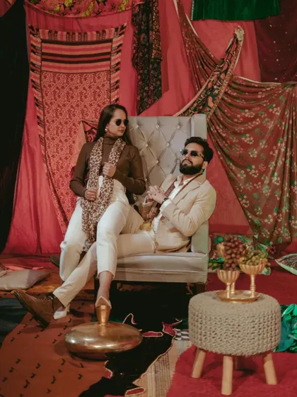 A stylish, high-fashion portrait of the couple on a lavishly decorated indoor set. This shot has a confident and modern editorial feel.