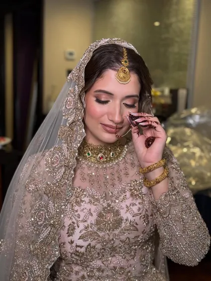 This close up captures the delicate details of the bride's makeup, including the soft pink eyeshadow and the traditional nose ring. The overall look is one of gentle, ethereal beauty.