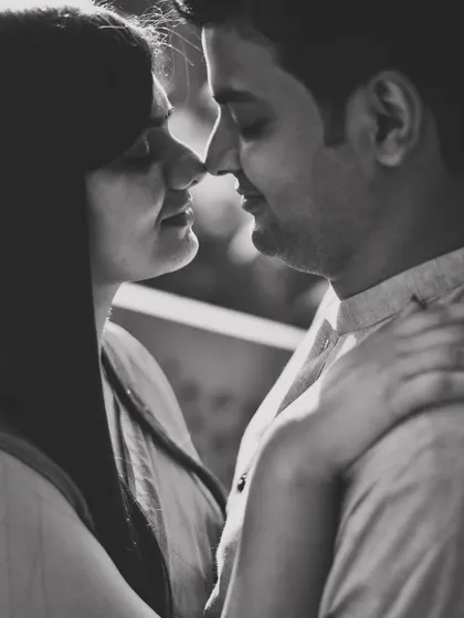A classic and romantic black and white close-up. This timeless portrait captures the gentle intimacy between the couple, nose to nose.