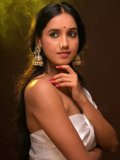 A soft and ethereal portrait with a focus on traditional Indian aesthetics. The warm, hazy light and the model's gentle expression give this image a dreamy, romantic quality.